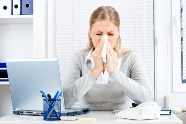 Woman covering nose while sneezing
